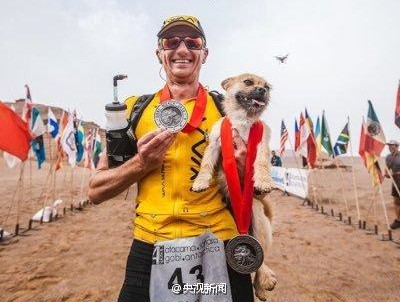 Marathon runner Dion Leonard holds a stray dog that followed him during an extreme marathon in Xinjiang Uygur Autonomous Region. Leonard had raised enough to take the dog named Gobi, which disappeared for days, back to Edinburgh, Scotland. (Photo/Weibo of CCTV)
