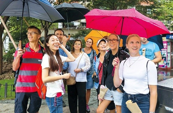 The rain cant dampen the smiles on the faces of these walkers who took part in one of the five free guided tours yesterday designed to highlight Shanghais beauty spots, history and culture. Their tour took in, among others, the historic Normandie Apartments, designed by architect Laszlo Hudec, Shanghai Camera History Museum, and the former residences of Chinese writer Ba Jin and cartoonist Zhang Leping. The walks were part of the ongoing Shanghai Tourism Festival.(Wang Rongjiang)