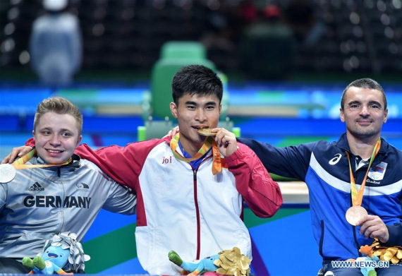 Cao Ningning (C) of China reacts during the medal presenting ceremony after Men's Singles Class 5 Gold Medal Match of Table Tennis against Valentin Baus of German at the 2016 Rio Paralympic Games in Rio de Janeiro, Brazil, Sept. 12, 2016. Cao Ningning won the Gold. (Photo: Xinhua/Zhu Zheng)