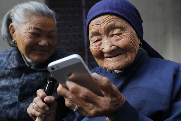 A 114-year-old woman surfs the internet using her cellphone in Lianyungang, Jiangsu province, last year. (Photo by Si Wei/For China Daily)