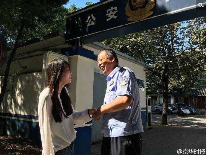 Feifei (L) goes to the police station at the Temple of Heaven to thank police officer Hou Xiangwei (R) on September 19. (Photo/Beijing Times) 