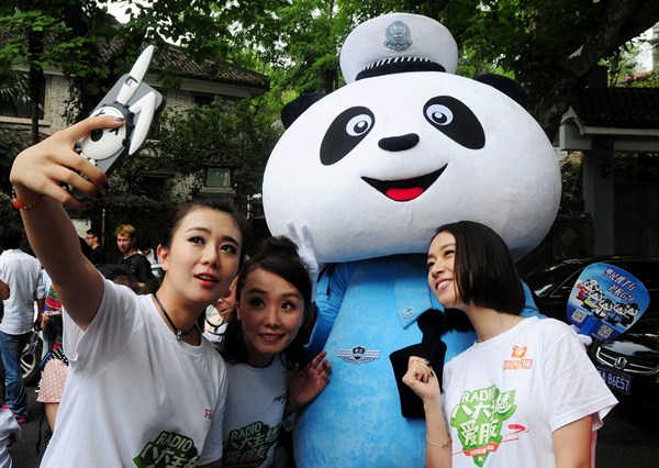 Tourists take a selfie with a Panda Police, around the West Lake area on Sept 8. Lian Guoqing/For China Daily