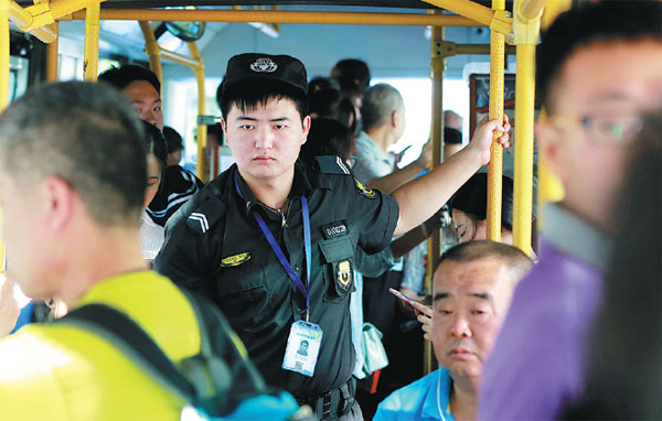 Security guard Hou Yongfei stays alert on duty on a bus in Beijing on Monday. The national public security and transport authorities have issued a notice saying cities and provinces need to add security guards. Feng Yongbin / China Daily