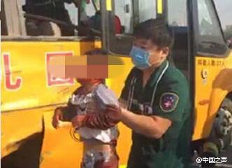 A medical worker saves an injured boy out of a school bus that collides with a truck at an intersection in Suixian County, central China's Henan Province. (Photo from Weibo)
