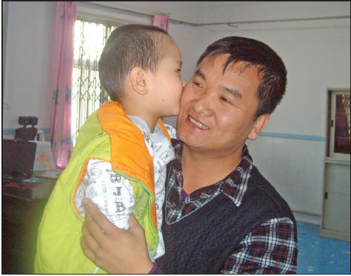 Zhu Zhenfeng with his 8-year-old son Xiao Ao at Anshan Children's Welfare Institute in Anshan, Liaoning province.(Photo Provided To China Daily)