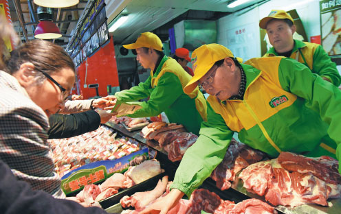 Lu Buxuan (right), founder of a pork retail chain, promotes products at a supermarket in Hangzhou, Zhejiang province.(Long Wei/for China Daily)