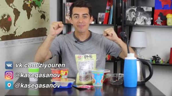 A screenshot from Kase Gasanov's video shows him trying Chinese convenient food.