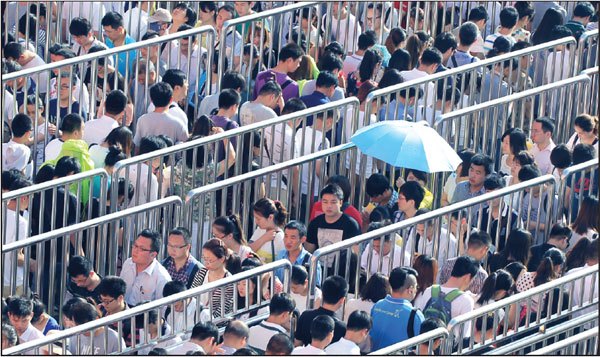 Commuters line up to enter the Tiantongyuan North Subway Station in Beijing at about 7:30 am. Located between the Fifth and Sixth Ring Roads, the station is crowded during the morning rush hour as local residents head to work downtown. Zhu Xingxin / China Daily