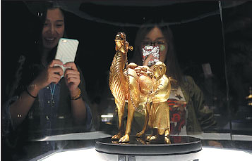 Visitors take photos on Monday of one of the relics of ancient civilizations along the Silk Road on display in Beijing's Badachu Park. Jiang Dong / China Daily