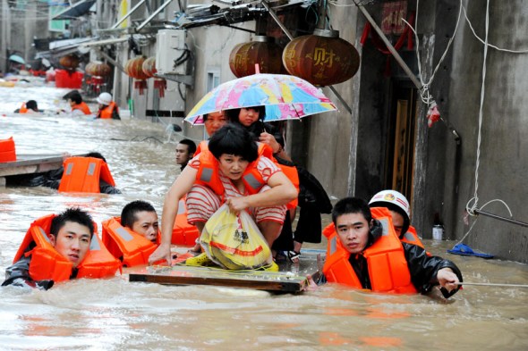 Firefighters and police evacuate residents stranded in Ningde, Fujian province, on Sept 28, 2015, after Typhoon Megi made landfall in the province. One death was reported in Fujian and four in Taiwan, as well as 27 missing in Zhejiang province. (Photo by Lyu Qiaoqin/ For China Daily)