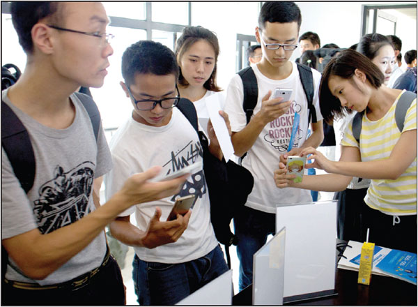 Students at Shanghai University of Finance and Economics sign up for a course on internet finance by scanning a code with their mobile phones.Photos By Gao Erqiang / China Daily