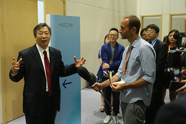 Yi Gang, vice-governor of People's Bank of China, answers questions of a foreign reporter on Sept 2 2016, prior to the G20 Leaders Summit to be held in Hangzhou, Zhejiang province. (Photo/China Daily)