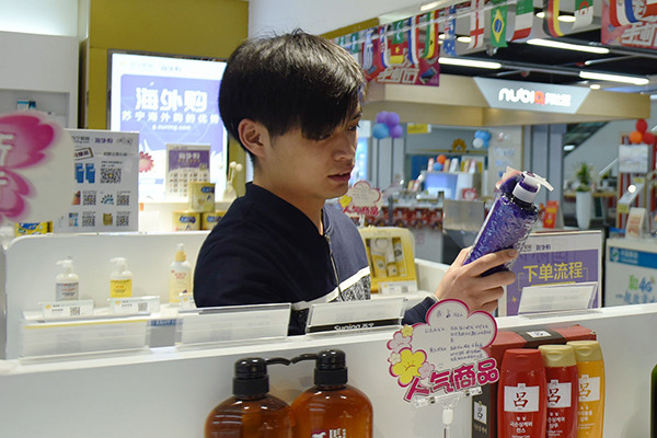 A customer shops for imported products in a cross-border e-commerce store in Hangzhou, Zhejiang province. (Photo/China Daily)