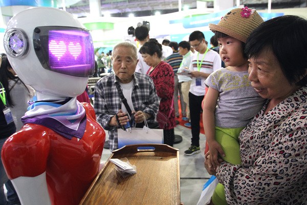 A robot attracts the attention of visitors at the China Beijing International High-Tech Expo on May 19.(Photo by Zhang Wei/China Daily)