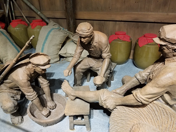 A statue shows soldiers applying Moutai wine on the leg of an injured comrade in Moutai town in Guizhou province. It is said that the wine was used extensively to treat wounds and illnesses during the Long March. Photo taken on Sept 10, 2016. (Photo by Faisal Kidwai/chinadaily.com.cn)