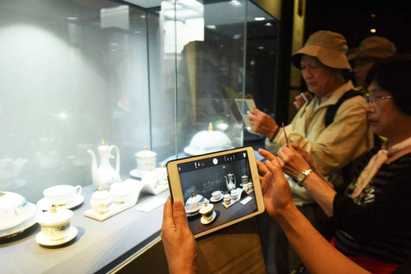 Exhibition visitors take photographs of the chinaware used at the G20 state banquet in Hangzhou, Zhejiang province on September 15, 2016. (Photo/china.com)