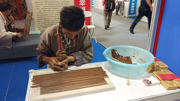 A man makes Tibetan incense at the exhibition in Beijing. (Photo/chinadaily.com.cn)
