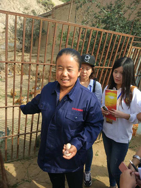 Gao Junxia, a villager in Shenjialing, shows reporters the organic eggs her chickens laid. (Photo by Ma Chi/chinadaily.com.cn)