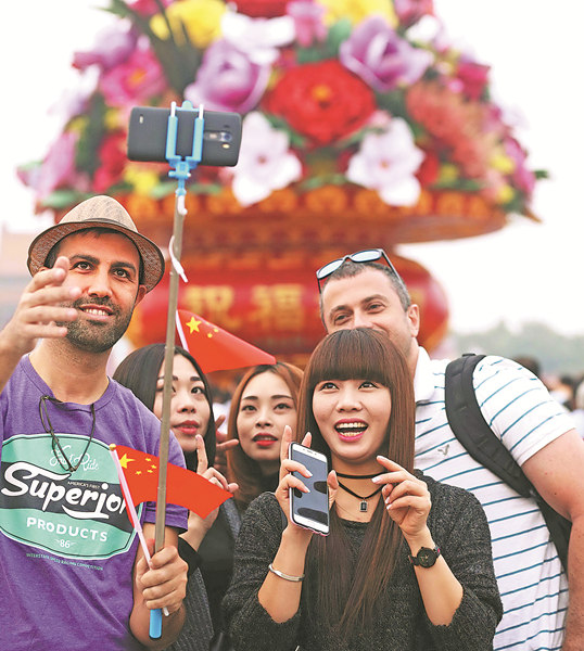 Visitors take selfie photos as crowds gather in Tian'anmen Square in Beijing on Saturday to celebrate National Day, marking the 67th anniversary of the founding of the People's Republic of China. Chen Xiaogen / for China Daily