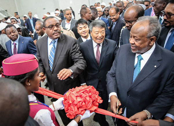 Xu Shaoshi (center), head of the National Development and Reform Commission and special envoy representing President Xi Jinping, watches as Hailemariam Desalegn, Ethiopia's prime minister (left), and Djibouti's President Ismail Omar Guelleh (right) cut the ribbon to launch the new railway from Addis Ababa, Ethiopia, to the port of Djibouti on Wednesday in Addis Ababa. QIN BIN / FOR CHINA DAILY