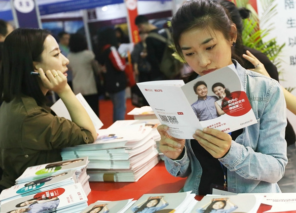 A student reads instructions of the International English Language Testing System during the 21st China International Educational Exhibition Tour in Beijing on May 7. A Qing / For China Daily
