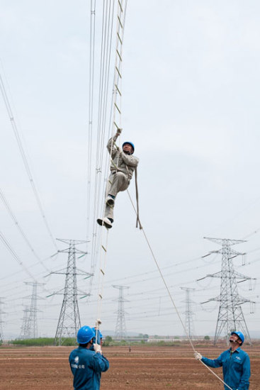An undated photo shows Zhao climbing up a rope ladder during a task in Dalian, Northeast China's Liaoning province. (Photo provided to chinadaily.com.cn)