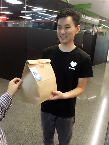 A Need Nutrition staff member delivers food to a Beijing office. (Photo provided to China Daily)