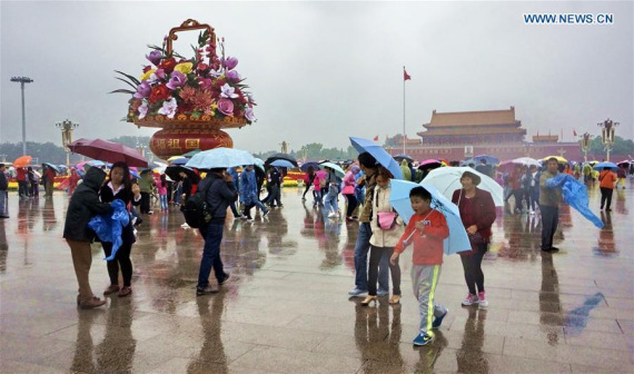 Tourists carrying umbrellas visit the Tian'anmen Square in Beijing, capital of China, Oct. 4, 2016, the fourth day of China's National Day holiday. (Photo: Xinhua/Li Xin)