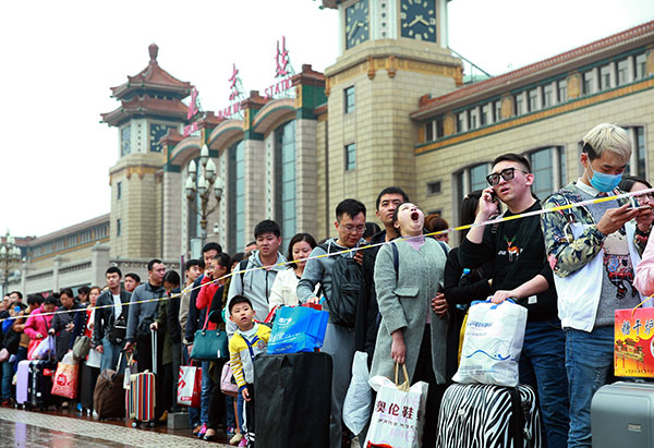 People line up to enter the subway station outside the Beijing Railway Station on Friday, the last day of the seven-day National Day holiday, after their return from traveling or visiting home during the vacation. (Photo by Zou Hong/China Daily)