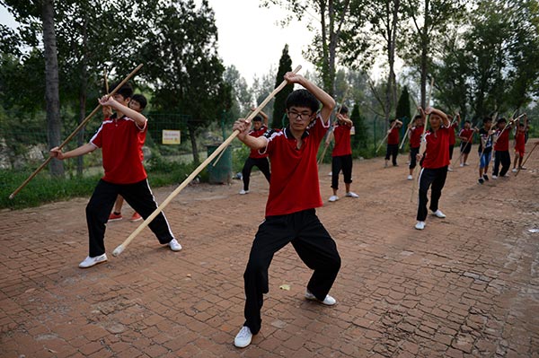 Children learn kung fu in a school of the Taguo Education Group in Dengfeng, Henan. (Photo by Xiang Mingchao/China Daily)