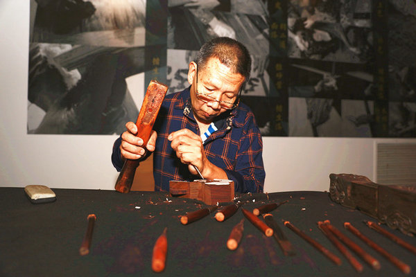 A man shows the craft of Su-style furniture making during the exhibition at Prince Kung's Mansion. Beijing, Oct 7, 2016. (Photo/pgm.org.cn)