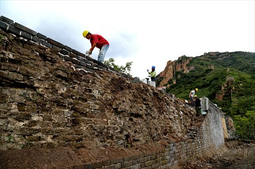 Workers repair a section of the Great Wall in Qinhuangdao, North China's Hebei Province on September 7. (Photo/Xinhua)