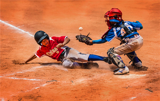 Teenager slides into home plate as opponent tries to catch the ball during the Panda Cup baseball tournament in Zhongshan, Guangdong province, in 2015. (Photo provided to chinadaily.com.cn)