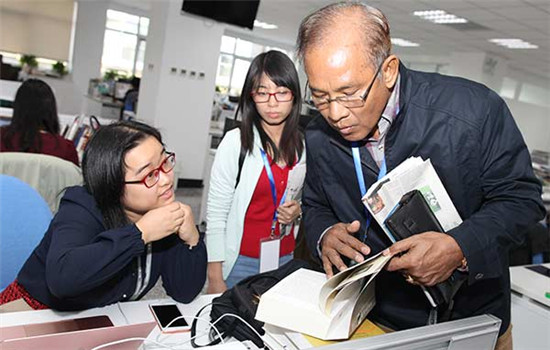 Win Tin (right), from Myanmar, and Pham Thi Hai Ha (middle), from Vietnam, visit China Daily newsroom during their training program in Beijing on Sept 28. (Photo/China Daily)