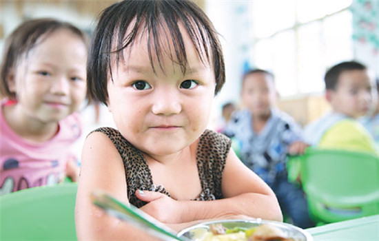Shi Jiahui, 3, eats lunch at the Houzhai Village Kindergarten in Tongren, Guizhou province. (Photos By Hou Liqiang / China Daily)