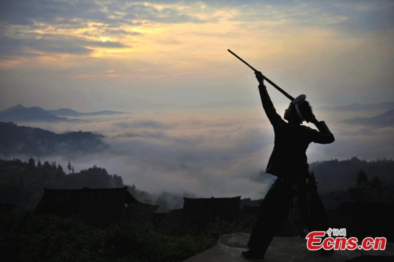 Gun Yuanli aims his gun at Biasha Village in Congjiang County, Southwest Chinas Guizhou Province. The Miao people in Basha are the only group in China that are permitted to carry guns.  (Photo: China News Service/Liang Guangyuan)