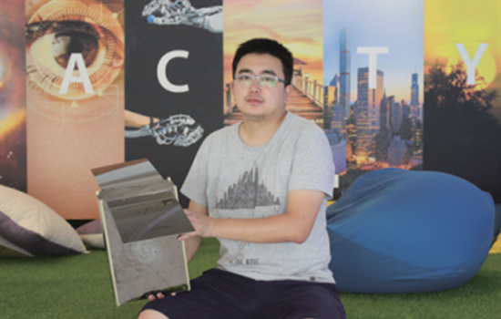 Yang Feng with a microsatellite developed by his company in Changsha, Hunan province.(Photo provided to China Daily)