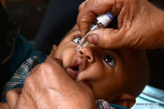 A Pakistani health worker gives a polio vaccine to a child on World Polio Day in eastern Pakistan's Lahore, Oct. 24, 2016. (Photo: Xinhua/Sajjad)