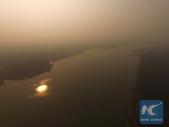   Aerial photo taken on Oct. 13, 2016 shows the Chaobai River shrouded in smog in Beijing, capital of China, Oct. 13, 2016. A blue alert for air pollution was issued on Thursday in Beijing. (Photo: Xinhua/Xing Guangli)