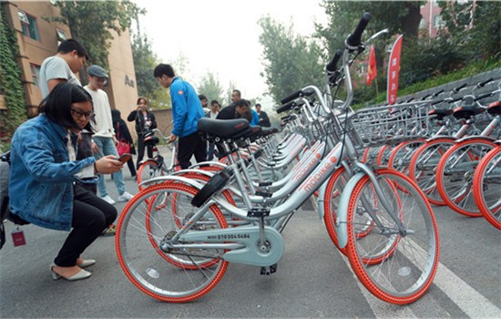 People examine Mobikes at a creative industry center in Beijing. (Photo by ZOU HONG/CHINA DAILY)