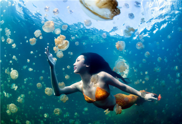 Li Da, a Chinese underwater model, freedives with jellyfish in a mermaid suit in western Pacific country of Palau. Provided by Yue Hongjun to China Daily