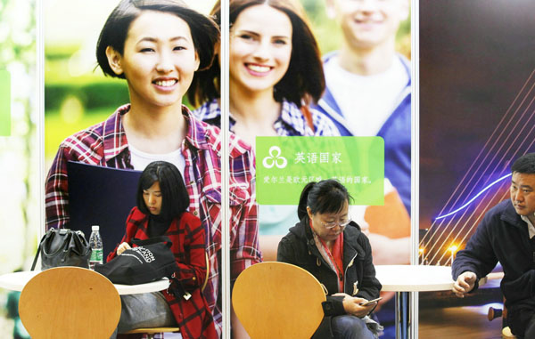 Visitors collect information at an exhibition booth of Irish education institutes on Oct 22 during the China Education Expo in Beijing. (A QING/ For CHINA DAILY)