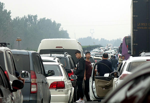 Traffic is halted on Friday on a highway in Xinxiang, Henan province, as people return after the holiday. (Photo by Sha Liang/China Daily)