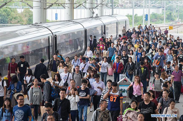 Passengers walk out of the Nanjing Railway Station in Nanjing, capital of East China's Jiangsu province, Oct 6, 2016. The country witnessed a travel peak on the last two days of the week-long National Day holiday as people started to return to school and work. (Photo/Xinhua)