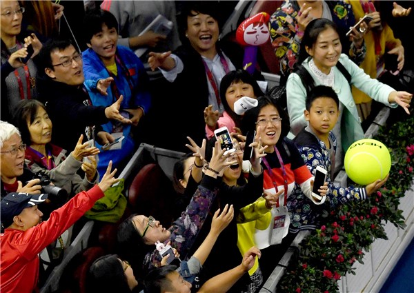 Members of the audience scramble for a wristband used by a tennis player after a match at the China Open in Beijing on Friday. (Photo by WEI XIAOHAO/CHINA DAILY)
