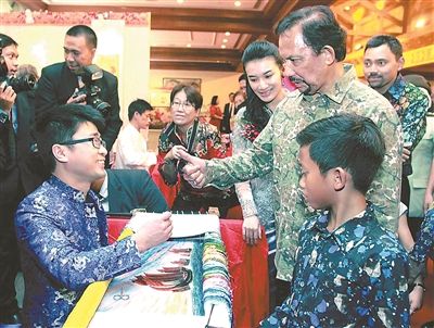 File photo shows Fu Jian receiving a thumb up from Sultan of Brunei Hassanal Bolkiah while stitching a piece of crewel embroidery in Brunei on March 16, 2015. (Photo/Xinhua)