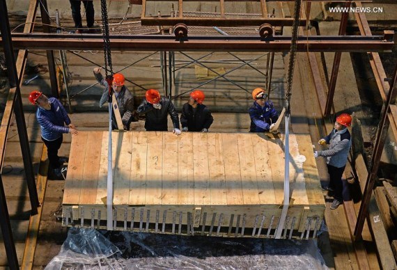 Staff members lift the main coffin in the Haihunhou (Marquis of Haihun) cemetery, east China's Jiangxi Province, Jan. 15, 2016. 