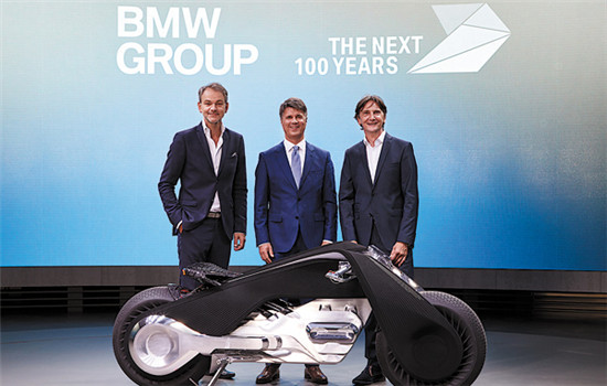 Adrian van Hooydonk (left), senior vice-president of BMW Group Design, Harald Krueger (center), chairman of the Board of Management of BMW Group, and Edgar Heinrich, head of BMW Motorrad Design, unveil the BMW Motorrad Vision Next 100 that debuted in Los Angeles on Oct 11. (Photo provided to China Daily)