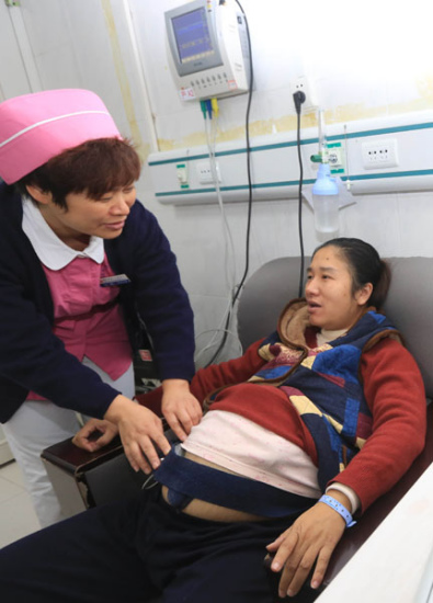 A nurse checks a pregnant woman at a hospital in Xiangyang, Hubei province, on Saturday. (GONG BO/ FOR CHINA DAILY)