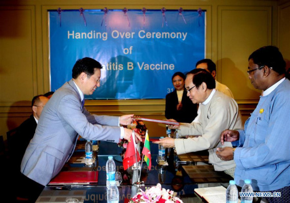 Chinese Ambassador to Myanmar Hong Liang (1st L) changes documents with Myanmar's Minister for Health and Sport Dr. Myint Htwe (2nd R) during a handover ceremony of Hepatitis B Vaccine in Yangon, Myanmar, Oct. 31, 2016.  (Photo：Xinhua/U Aung)